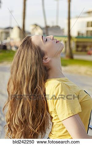 Stock Image - Caucasian woman tossing her hair. Fotosearch
