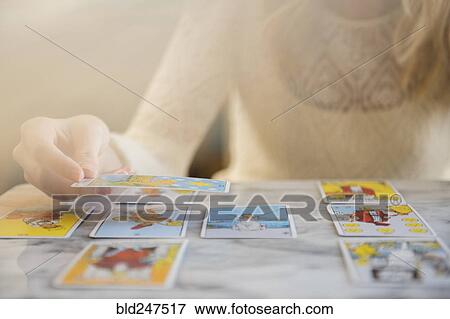 Stock Photo - Caucasian woman using tarot cards. Fotosearch