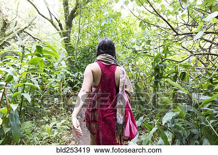 Stock Photo - Caucasian woman walking in forest. Fotosearch