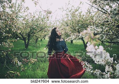 Caucasian woman walking near flowering trees View Large Photo Image Picture - Caucasian woman walking near flowering trees. Fotosearch