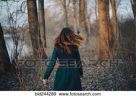 Caucasian woman walking near trees and river View Large Photo Image Stock Photo - Caucasian woman walking near trees and river. Fotosearch