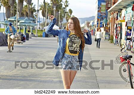 Stock Photo - Caucasian woman walking on Venice Beach sidewalk, Venice, California, United States. Fotosearch