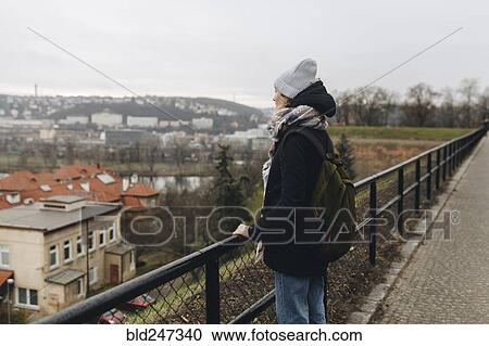 Caucasian woman wearing backpack admiring scenic view of city View Large Photo Image Stock Image - Caucasian woman wearing backpack admiring scenic view of city. Fotosearch