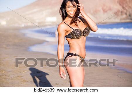 Stock Photo - Caucasian woman wearing bikini on beach. Fotosearch