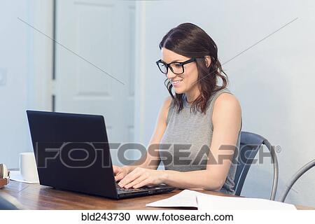 Caucasian woman wearing eyeglasses using laptop View Large Photo Image Stock Image - Caucasian woman wearing eyeglasses using laptop. Fotosearch
