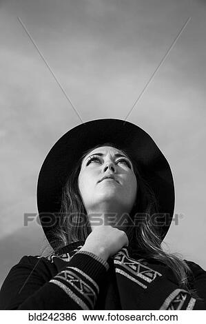 Stock Photograph - Caucasian woman wearing hat looking up. Fotosearch