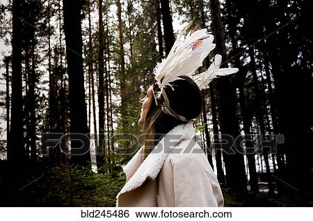 Stock Photograph - Caucasian woman wearing headdress in forest. Fotosearch