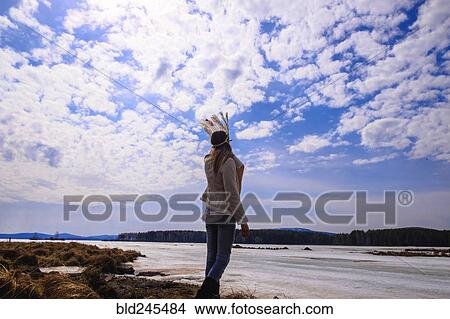 Picture - Caucasian woman wearing headdress near river. Fotosearch