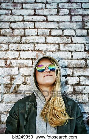 Caucasian woman wearing sunglasses near brick wall View Large Photo Image Stock Image - Caucasian woman wearing sunglasses near brick wall. Fotosearch
