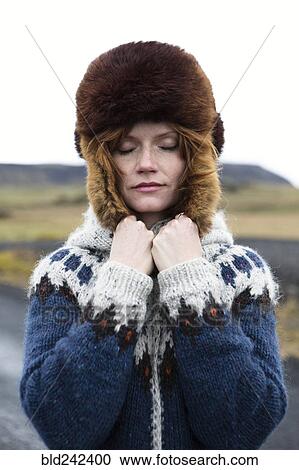 Stock Image - Caucasian woman wearing sweater and fur hat. Fotosearch