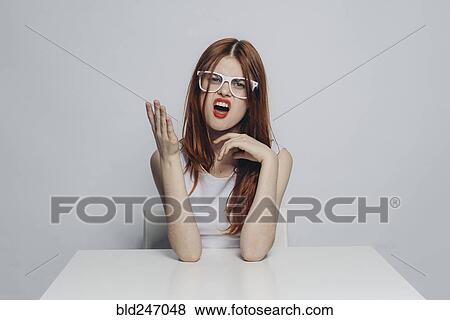 Caucasian woman with attitude sitting at table wearing white eyeglasses View Large Photo Image Stock Photo - Caucasian woman with attitude sitting at table wearing white eyeglasses. Fotosearch
