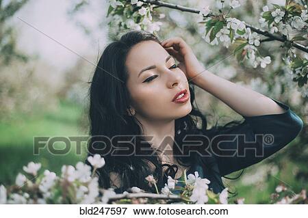 Caucasian woman with hand and hair near flowering tree View Large Photo Image Stock Photo - Caucasian woman with hand and hair near flowering tree. Fotosearch