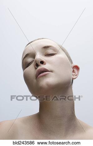 Stock Photograph - Caucasian woman with shaved-head and eyes closed. Fotosearch