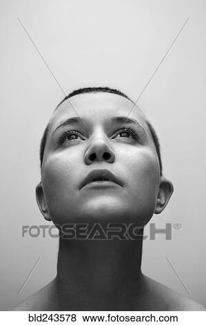 Stock Photo - Caucasian woman with shaved-head looking up. Fotosearch