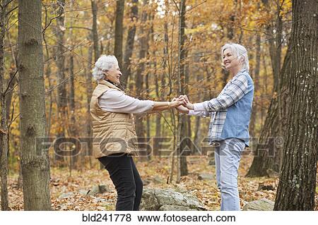 Stock Photo - Caucasian women dancing outdoors in autumn. Fotosearch