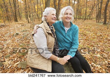 Stock Photo - Caucasian women hugging outdoors in autumn. Fotosearch