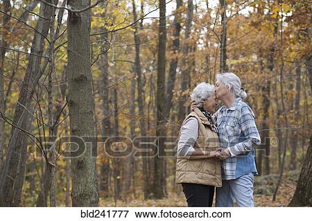 Stock Photo - Caucasian women kissing outdoors in autumn. Fotosearch