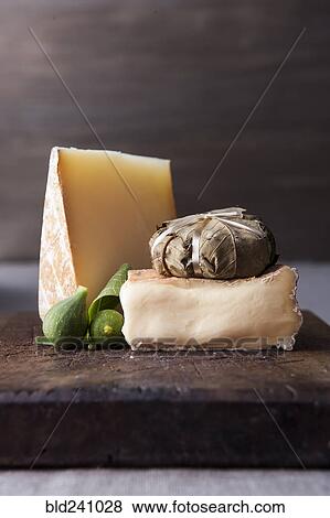 Stock Photo - Cheese and fruit on wooden cutting board. Fotosearch