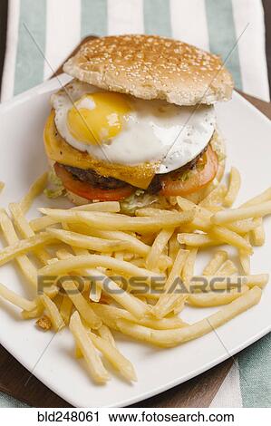 Cheeseburger with egg and french fries View Large Photo Image Stock Image - Cheeseburger with egg and french fries. Fotosearch