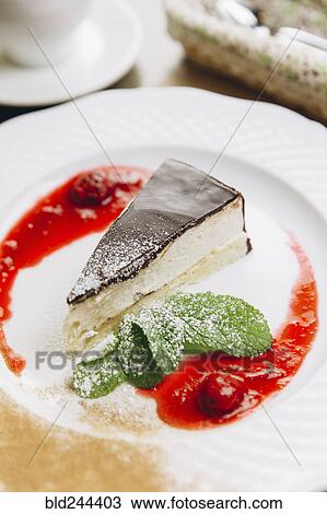 Cheesecake slice on plate with powdered sugar and berry sauce View Large Photo Image Stock Image - Cheesecake slice on plate with powdered sugar and berry sauce. Fotosearch