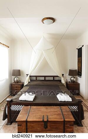 Chest near wooden bed in bedroom View Large Photo Image Stock Image - Chest near wooden bed in bedroom. Fotosearch