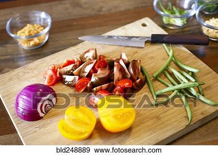 Stock Photo - Chopped vegetables on cutting board. Fotosearch