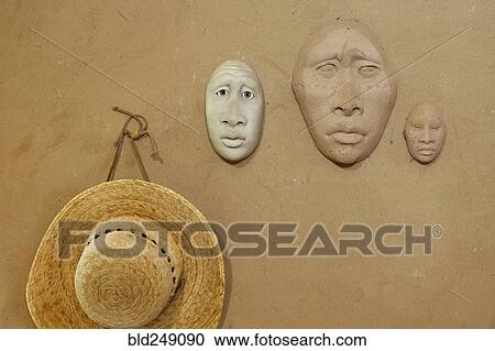 Clay masks and hat hanging on wall View Large Photo Image Stock Image - Clay masks and hat hanging on wall. Fotosearch