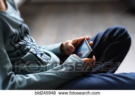 Close up of Caucasian boy playing with cell phone View Large Photo Image Stock Photo - Close up of Caucasian boy playing with cell phone. Fotosearch