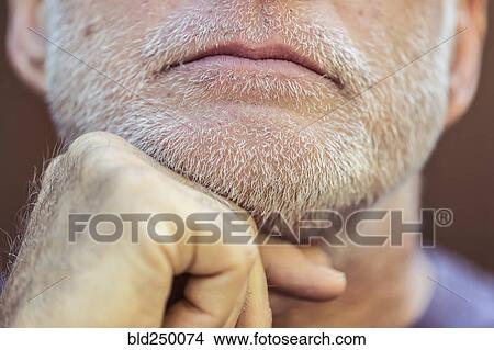 Close up of Caucasian man with hand on chin View Large Photo Image Picture - Close up of Caucasian man with hand on chin. Fotosearch