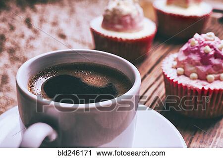Stock Image - Close up of coffee and cupcakes. Fotosearch