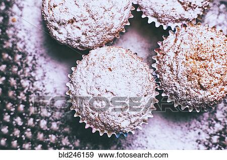 Stock Photo - Close up of cupcakes covered with powdered sugar. Fotosearch