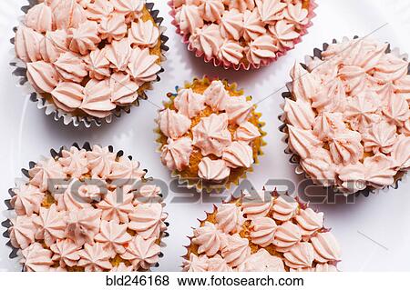 Stock Photo - Close up of cupcakes with pink frosting. Fotosearch