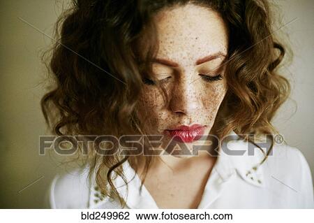 Stock Image - Close up of Mixed Race woman looking down. Fotosearch