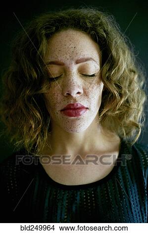 Picture - Close up of Mixed Race woman with eyes closed. Fotosearch