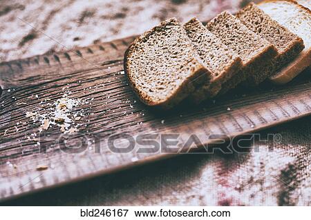 Stock Photo - Close up of slices of bread and crumbs on wooden tray. Fotosearch
