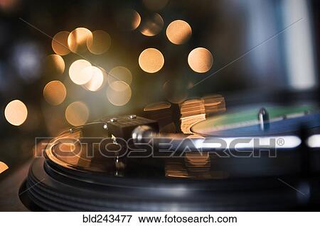 Stock Photo - Close up of tonearm on spinning record player. Fotosearch