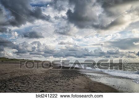 Stock Image - Clouds over ocean beach. Fotosearch