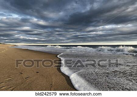 Stock Photo - Clouds over ocean beach. Fotosearch