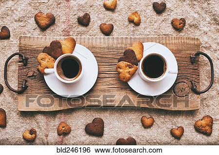 Stock Photograph - Coffee and heart-shape cookies on wooden tray. Fotosearch