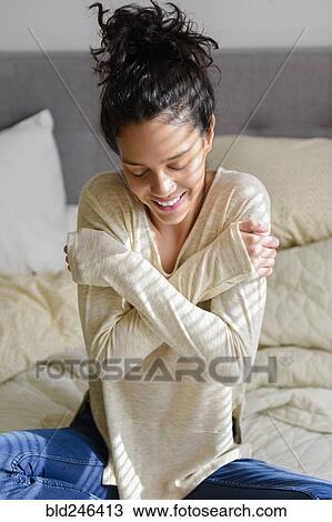 Cold Hispanic woman sitting on bed View Large Photo Image Stock Image - Cold Hispanic woman sitting on bed. Fotosearch
