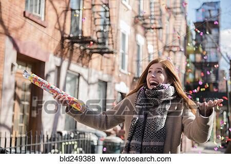 Stock Photo - Confetti falling on Caucasian woman wearing scarf. Fotosearch