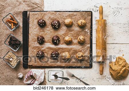 Stock Photo - Cookie dough on baking sheet near rolling pin and ingredients. Fotosearch