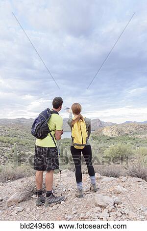 Stock Image - Couple admiring scenic view in desert. Fotosearch
