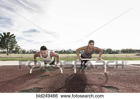 Couple doing push-ups outdoors View Large Photo Image Stock Photograph - Couple doing push-ups outdoors. Fotosearch
