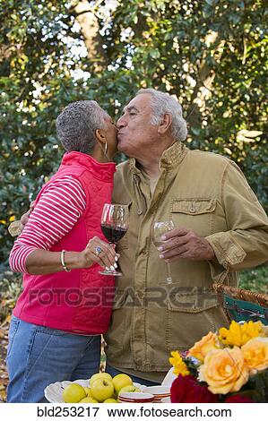 Couple drinking wine and kissing outdoors View Large Photo Image Stock Photo - Couple drinking wine and kissing outdoors. Fotosearch