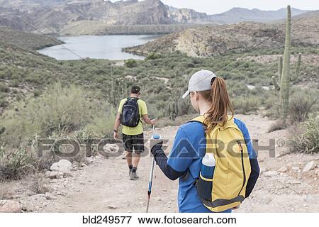 Couple hiking on rocky path in desert View Large Photo Image Stock Photo - Couple hiking on rocky path in desert. Fotosearch