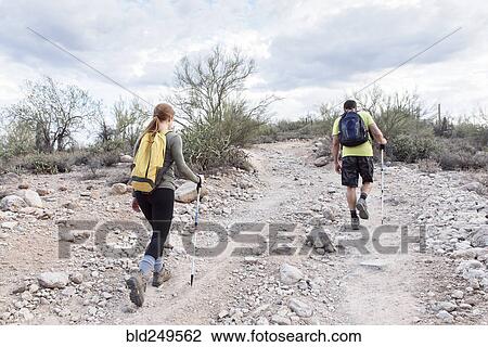 Stock Image - Couple hiking on rocky path. Fotosearch