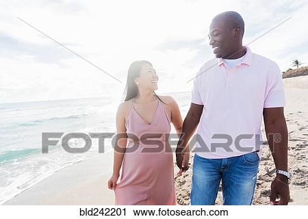 Couple holding hands walking on beach View Large Photo Image Stock Image - Couple holding hands walking on beach. Fotosearch