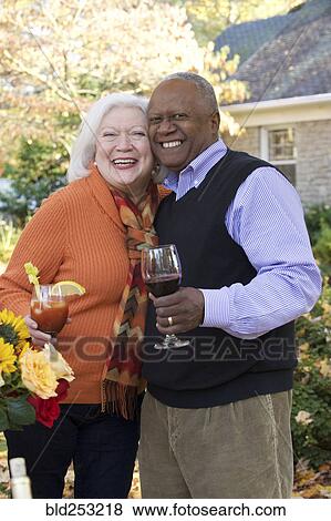 Couple hugging outdoors and enjoying wine and cocktail View Large Photo Image Stock Photo - Couple hugging outdoors and enjoying wine and cocktail. Fotosearch