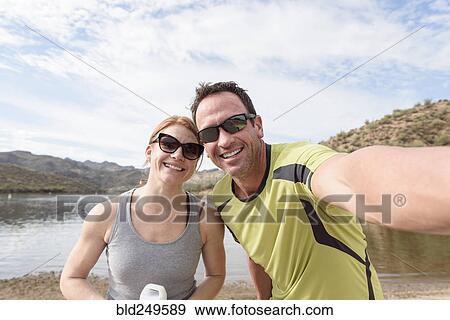 Stock Photo - Couple posing for selfie at lake. Fotosearch